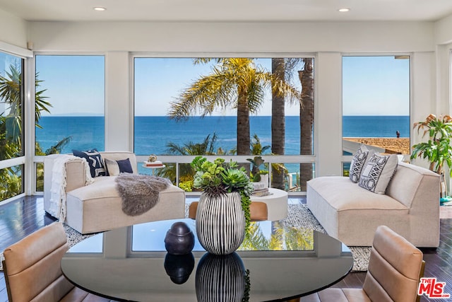 sunroom / solarium featuring plenty of natural light and a water view