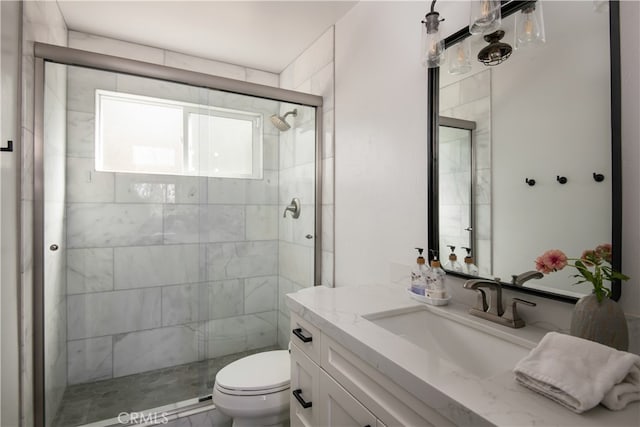 bathroom featuring vanity, toilet, and a shower with door