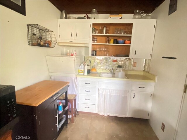 laundry area featuring sink and light tile patterned flooring