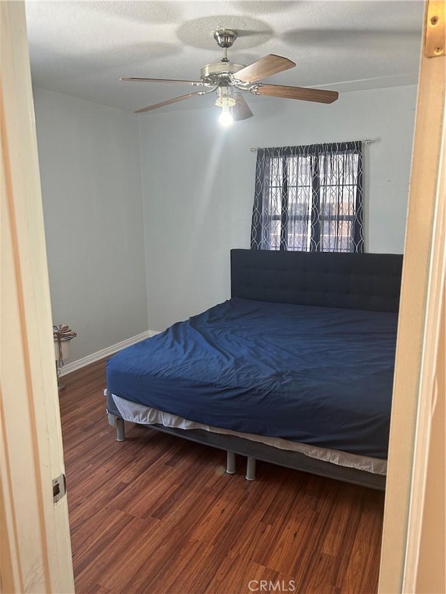 bedroom with wood-type flooring, a textured ceiling, and ceiling fan