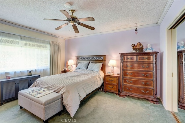 carpeted bedroom with a textured ceiling, ceiling fan, and ornamental molding