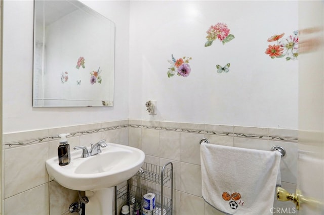 bathroom featuring sink and tile walls