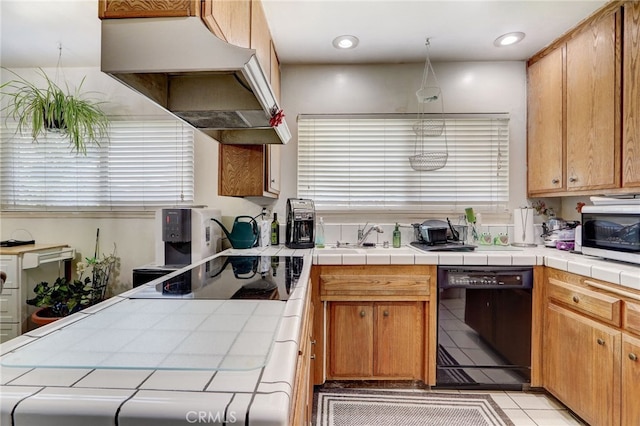 kitchen with tile counters, light tile patterned flooring, black appliances, and decorative light fixtures