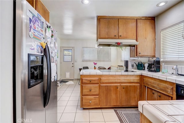 kitchen with tile countertops, stainless steel refrigerator with ice dispenser, light tile patterned floors, cooktop, and kitchen peninsula