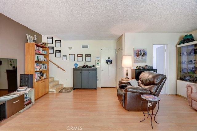 living room featuring light hardwood / wood-style floors and a textured ceiling