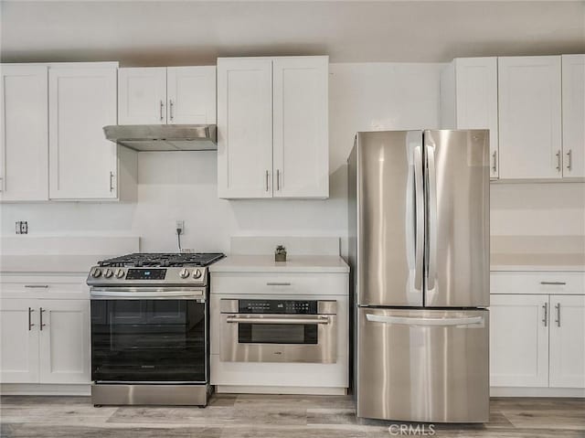 kitchen featuring appliances with stainless steel finishes, white cabinetry, and light hardwood / wood-style flooring