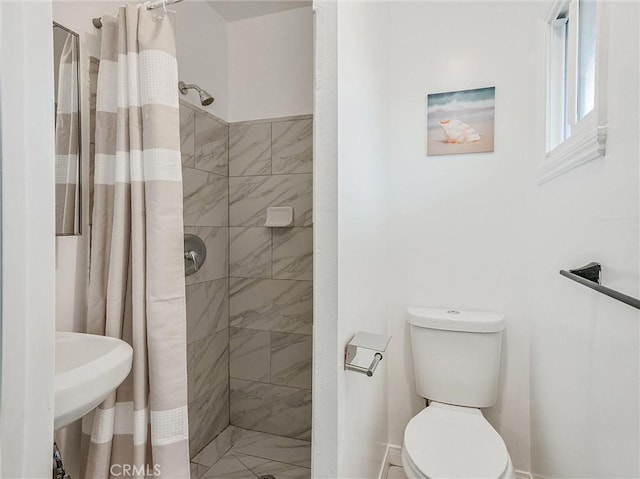 bathroom featuring toilet and curtained shower