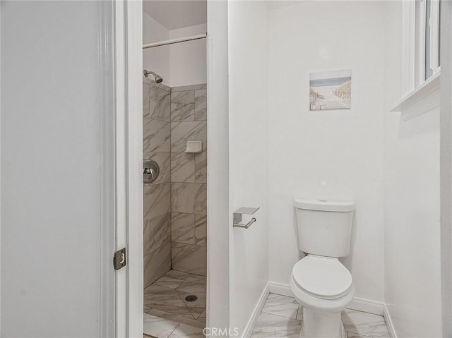 bathroom with toilet and a tile shower