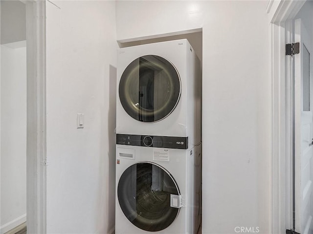 clothes washing area featuring stacked washer and dryer