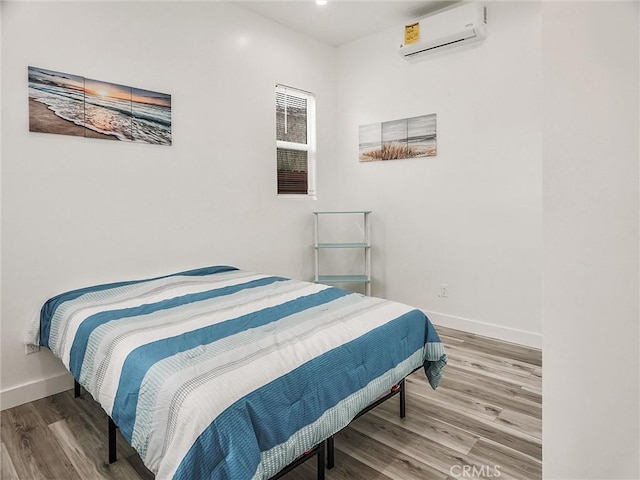 bedroom featuring a wall unit AC and hardwood / wood-style floors