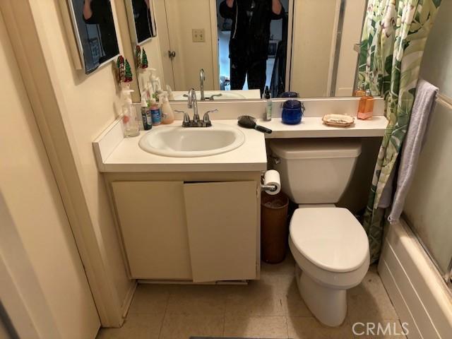 full bathroom featuring shower / bathtub combination with curtain, vanity, tile patterned flooring, and toilet