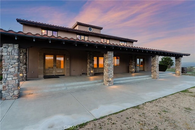 back house at dusk with a patio area
