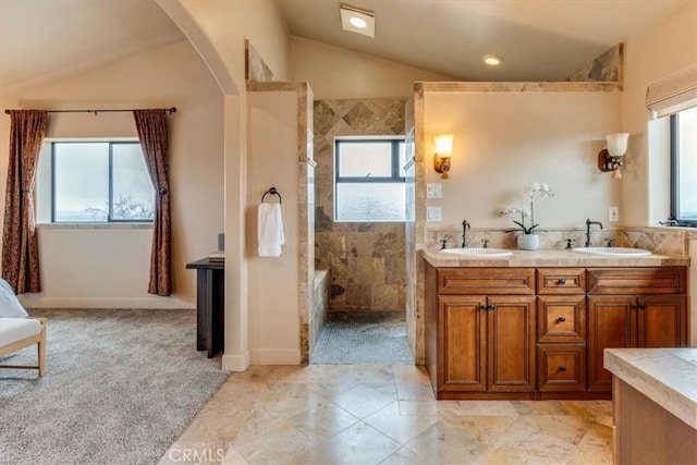 bathroom with tile patterned flooring, vanity, lofted ceiling, and tiled shower