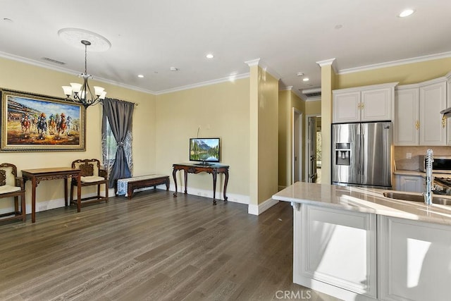 kitchen featuring stainless steel refrigerator with ice dispenser, ornamental molding, white cabinets, dark hardwood / wood-style flooring, and a chandelier