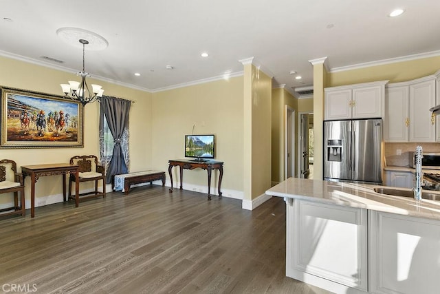 kitchen featuring dark wood finished floors, visible vents, white cabinets, a sink, and stainless steel fridge with ice dispenser