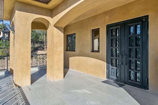 property entrance featuring french doors and stucco siding