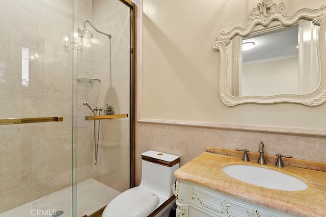 full bath featuring a stall shower, a wainscoted wall, vanity, and toilet