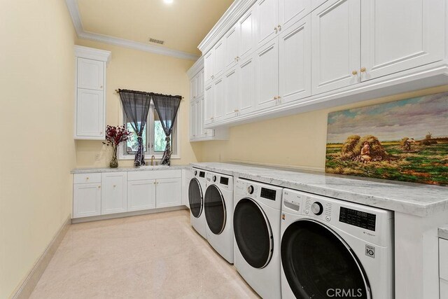 clothes washing area featuring cabinets, crown molding, washer and dryer, and sink