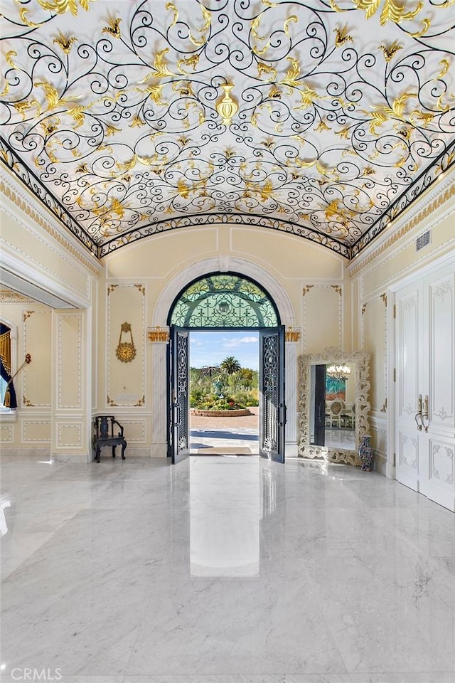 foyer featuring crown molding and a towering ceiling