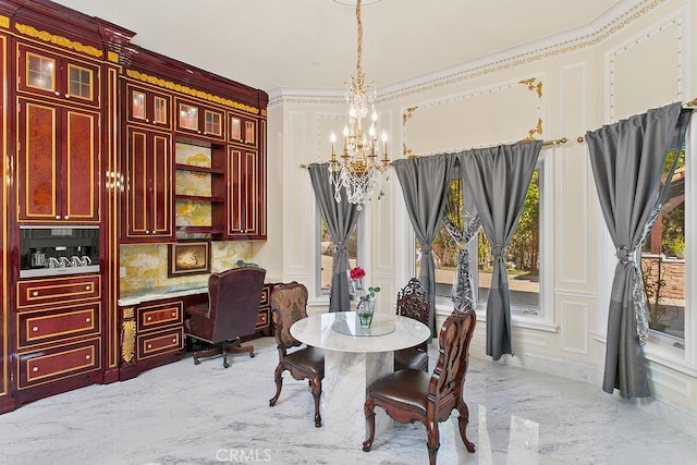 dining space with an inviting chandelier, ornamental molding, and built in desk