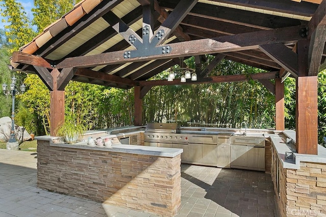 view of patio / terrace featuring a sink, exterior kitchen, area for grilling, and a gazebo