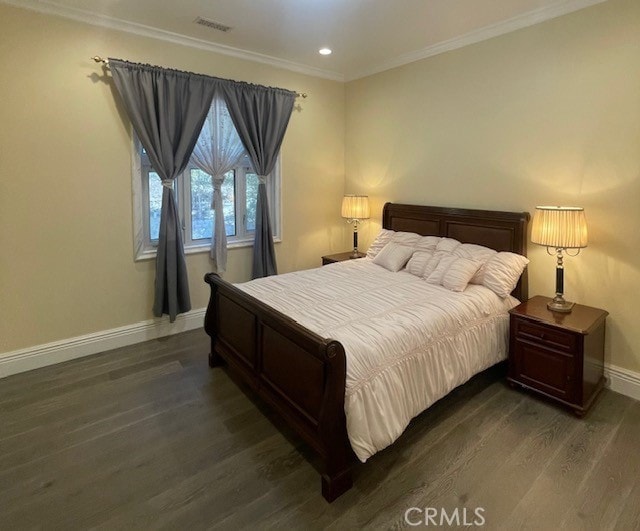 bedroom featuring ornamental molding and dark hardwood / wood-style flooring