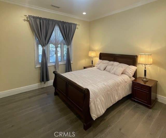 bedroom with dark wood-type flooring, visible vents, ornamental molding, and baseboards