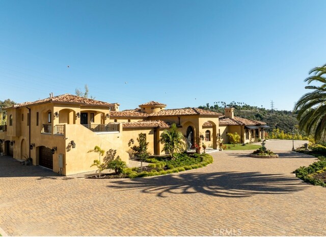 mediterranean / spanish-style home with a balcony and a garage