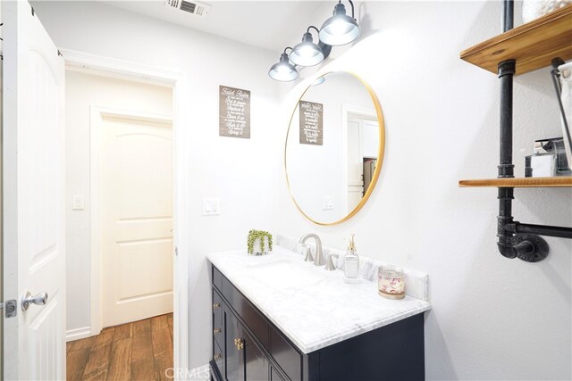 2425 N Fillmore Ave, Rialto, CA 92377 - bathroom featuring visible vents, wood finished floors, and vanity