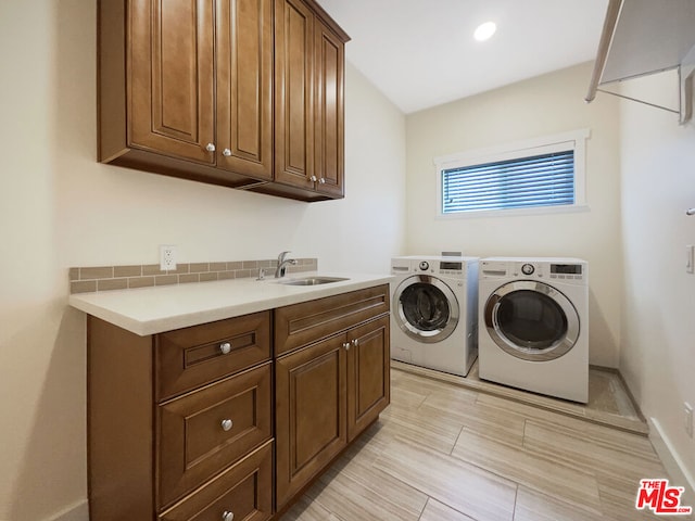 laundry room with washer and clothes dryer, cabinets, and sink