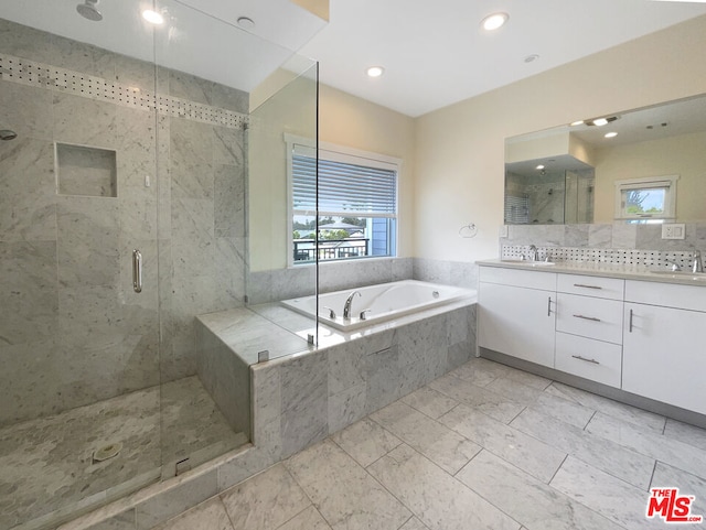 bathroom with separate shower and tub, vanity, and a healthy amount of sunlight