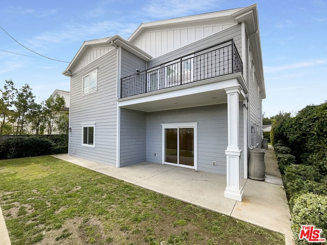 rear view of house with a yard, a balcony, and a patio