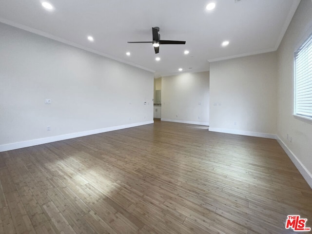 spare room featuring ornamental molding, ceiling fan, and dark wood-type flooring