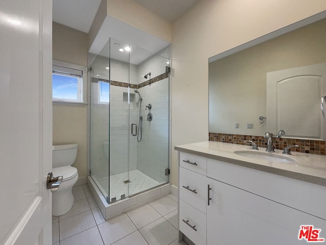 bathroom featuring vanity, tile patterned flooring, decorative backsplash, toilet, and a shower with shower door