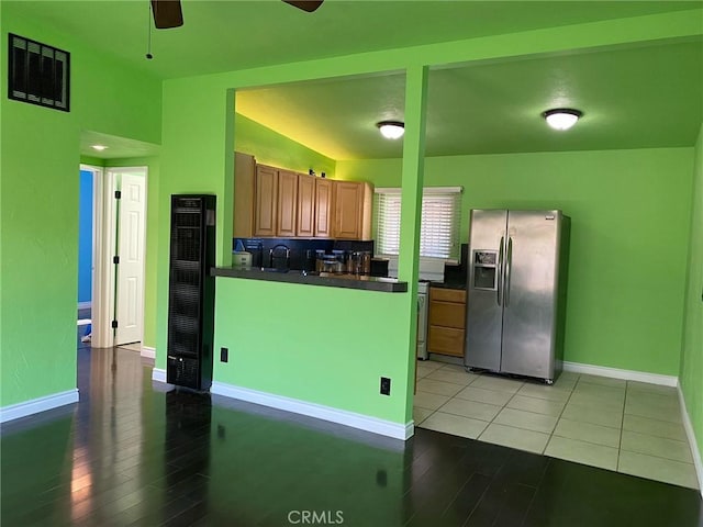 kitchen featuring stainless steel fridge, sink, light hardwood / wood-style floors, and vaulted ceiling