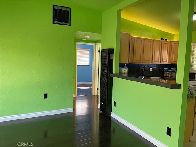 kitchen with decorative backsplash, sink, dark wood-type flooring, and vaulted ceiling