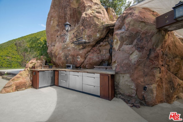 view of patio with exterior kitchen and a mountain view