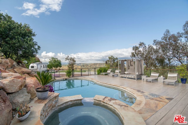 view of swimming pool with an in ground hot tub, a mountain view, and a patio