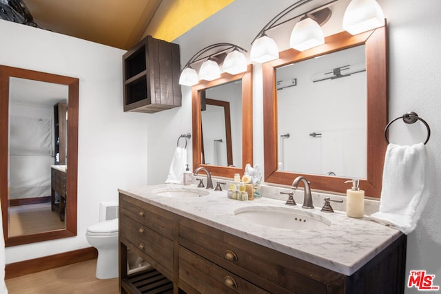 bathroom with lofted ceiling, vanity, hardwood / wood-style floors, and toilet