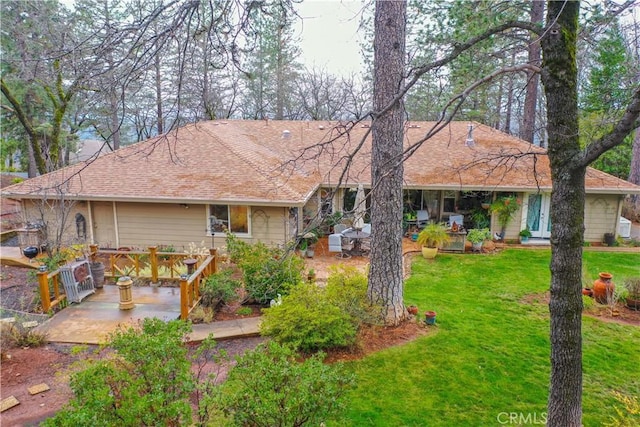 view of front of house featuring a patio and a front lawn