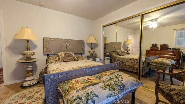 bedroom featuring light hardwood / wood-style floors, ceiling fan, and a closet