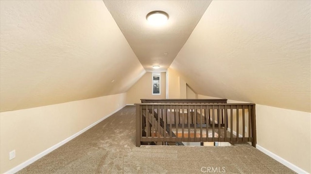 additional living space featuring lofted ceiling, a textured ceiling, and carpet floors