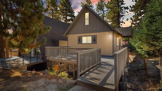 back house at dusk with a deck