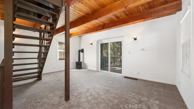 basement featuring a wood stove, carpet, and wooden ceiling