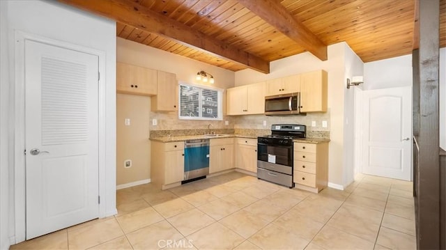 kitchen with light tile patterned flooring, appliances with stainless steel finishes, light stone counters, and sink