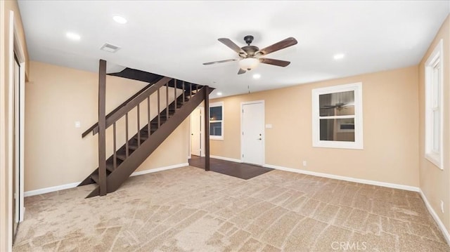 interior space with ceiling fan, a healthy amount of sunlight, and light carpet