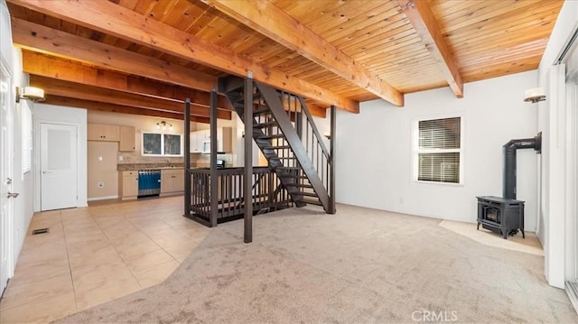 carpeted living room featuring beam ceiling, a wood stove, and wood ceiling