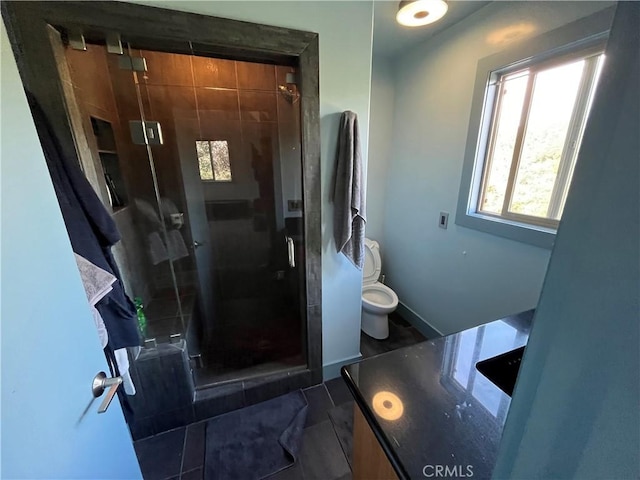 bathroom featuring toilet and a shower with shower door