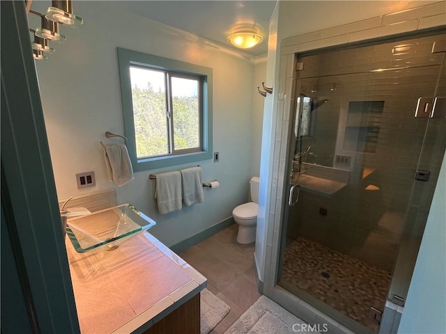 bathroom with toilet, vanity, and an enclosed shower