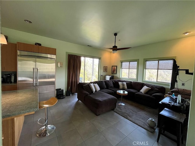 living room with ceiling fan and light tile patterned flooring